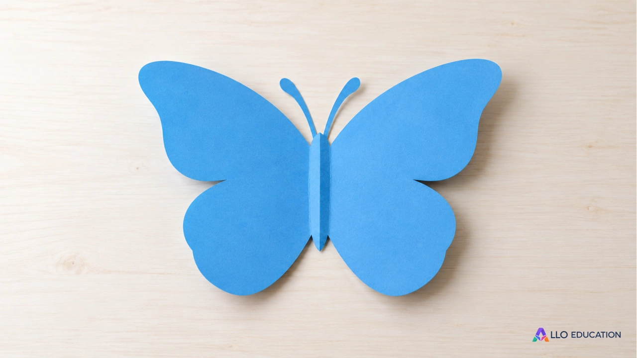 Un papillon découpé dans du papier bleu, ouvert autour d’un pli central.